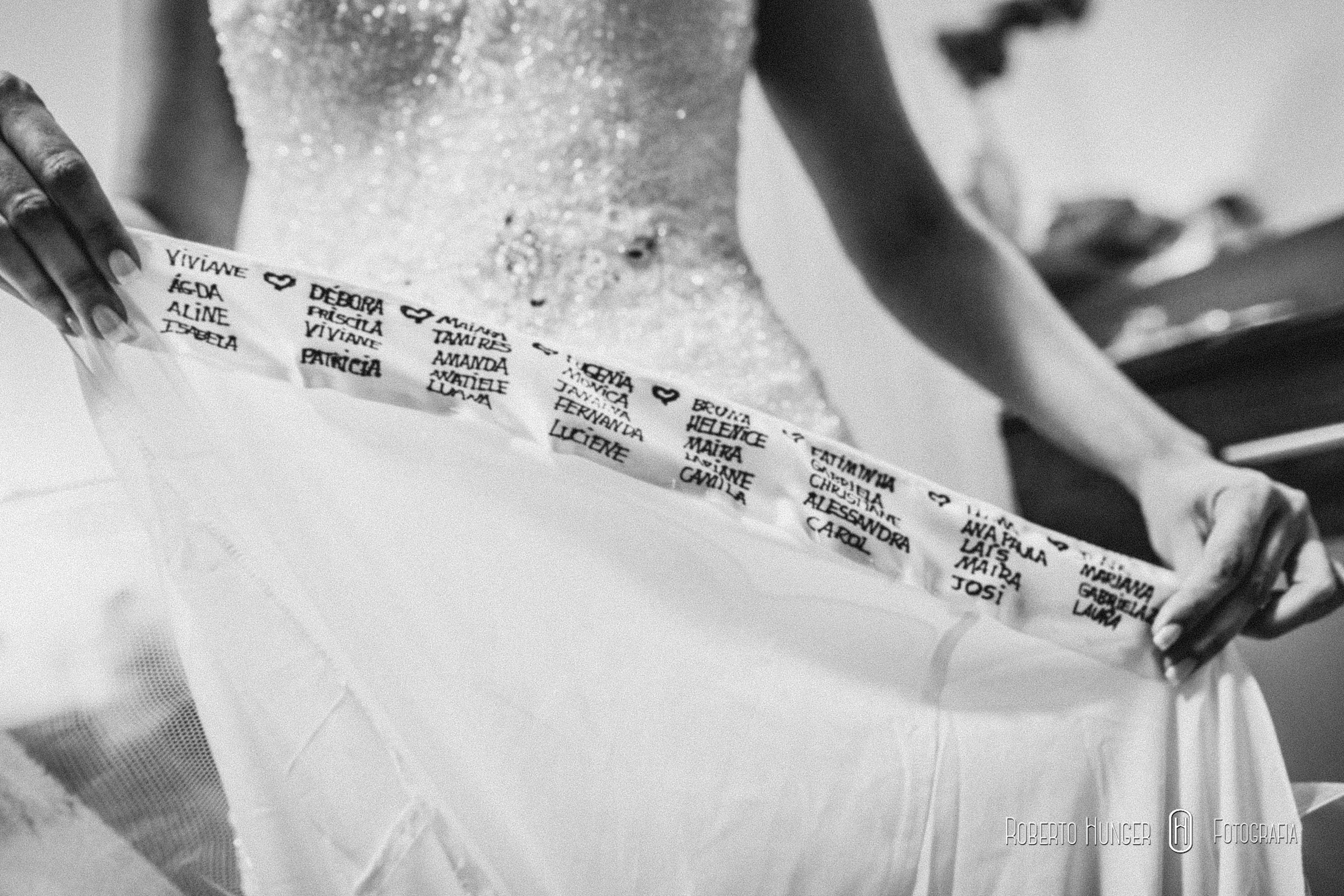 noiva escrevendo o nome das madrinhas na barra do vestido, noiva em pouso alegre, vestidos de noiva em pouso alegre